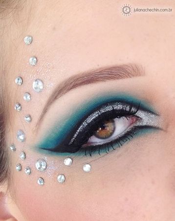 Pretty teal and silver eye shadow with stylized black eye liner and crystal enhancements. | Color guard makeup, Rhinestone makeup, Glitter eye makeup