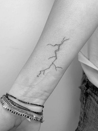 Lightning bolt tattoo on the inner forearm.
