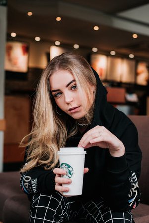 Photo of Sitting Woman Holding a Starbucks To Go Cup · Free Stock Photo