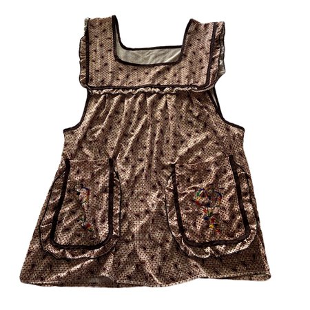 brown cottage core apron style dress with paisley pattern, flower embroidered pockets, and an open back