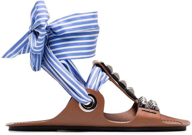 Brown gladiator sandals with studs and black ribbon and a blue and white striped ribbon
