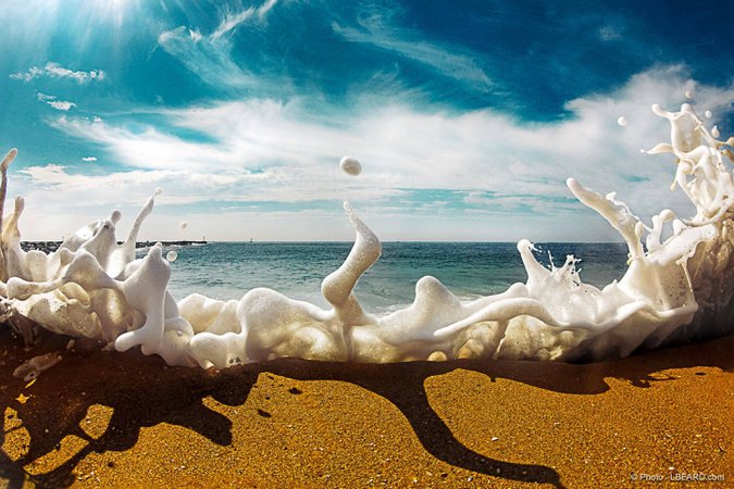 Sea foam crashes over the sand. : pics