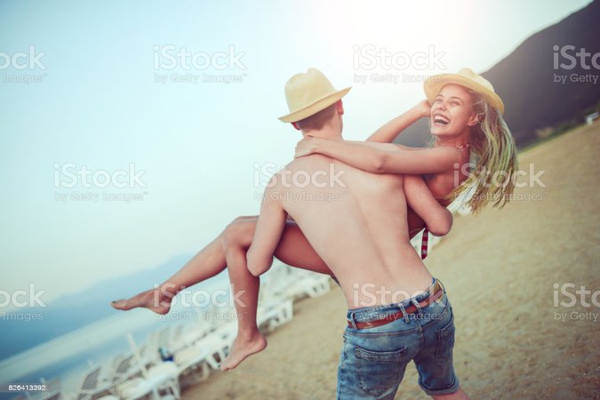 boyfriend holding girlfriend in his arms - beach