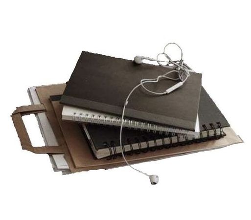 stack of notebooks with earbuds draped on top