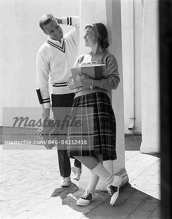 1950s 1960s COLLEGE HIGH SCHOOL AGED TEENAGE BOY & GIRL SMILING FLIRTING WEARING SADDLE SHOES PLAID PLEATED SKIRT TENNIS SWEATER - Stock Photos : Masterfile
