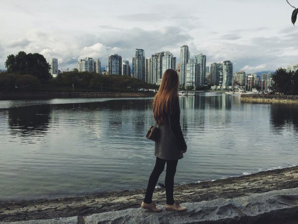Free stock photo of Girl walking on the seafront near water, Vancouver city behind - Reshot