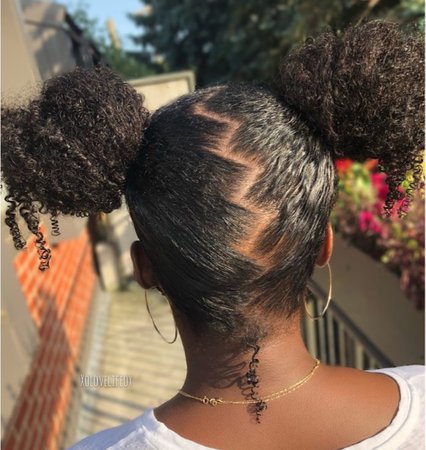 Two buns on curly hair with  zig zag part