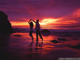 romantic couple dancing in the dark on beach