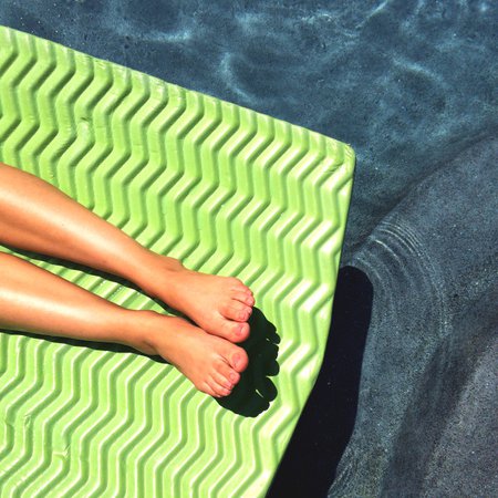 Free stock photo of Young woman laying out in pool - Reshot