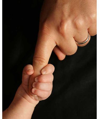 baby holding adult finger