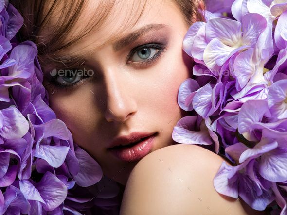Pretty woman with bright makeup. Beautiful white girl with purple flowers. Stock Photo by valuavitaly