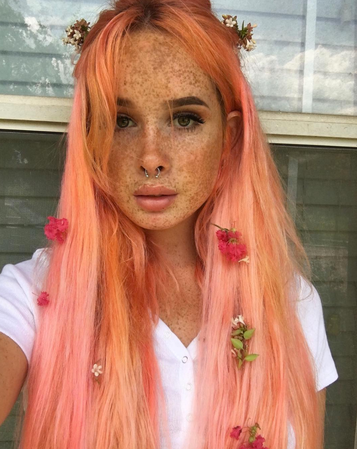 Girl with pink orange ombre hair and freckles with piercings