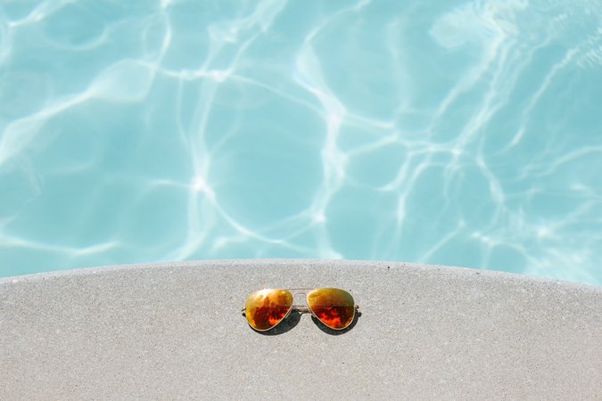 gold framed orange lens Aviator-style sunglasses beside pool photo – Free Summer Image on Unsplash